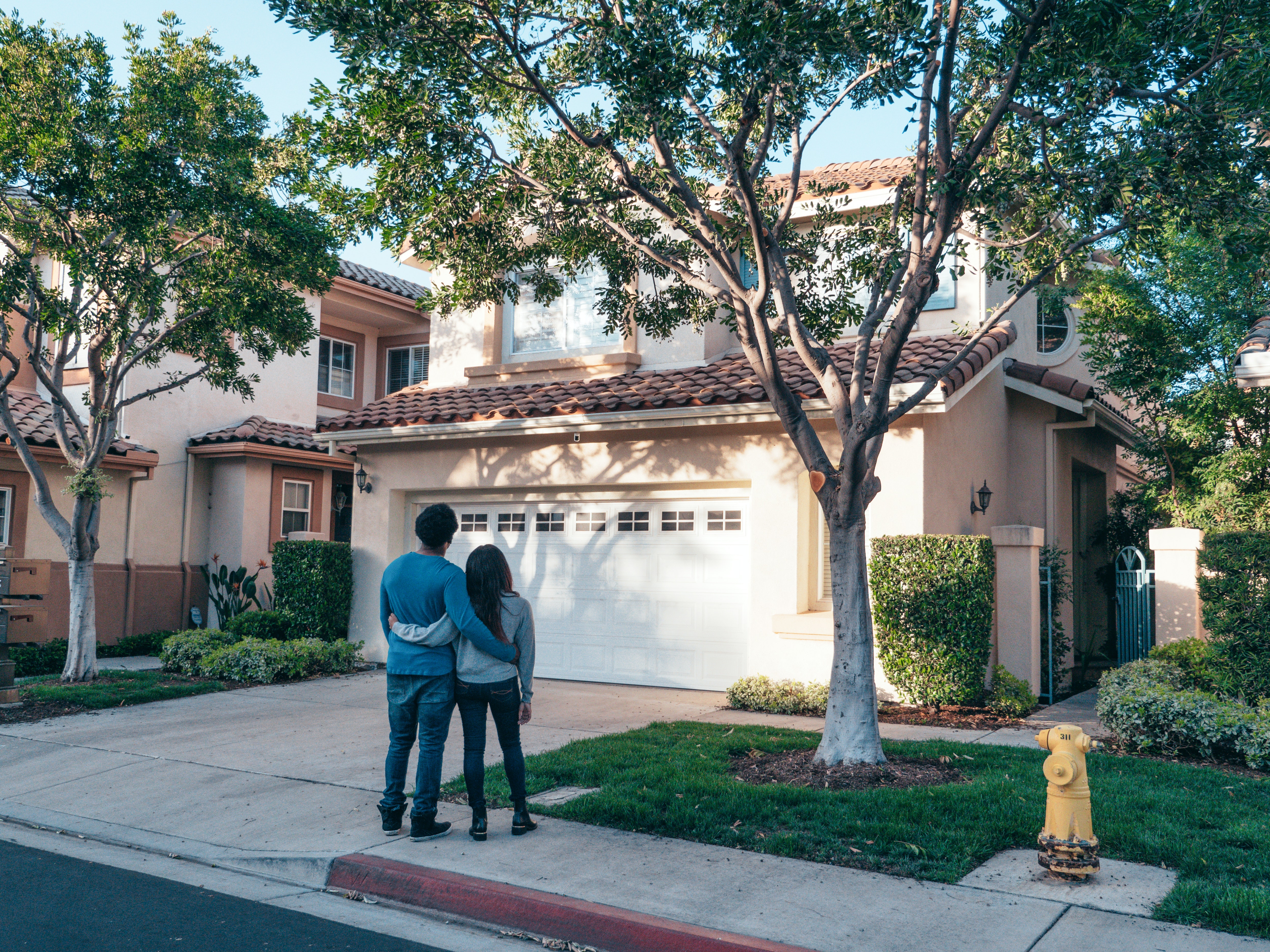 Couple in front of stucco home
